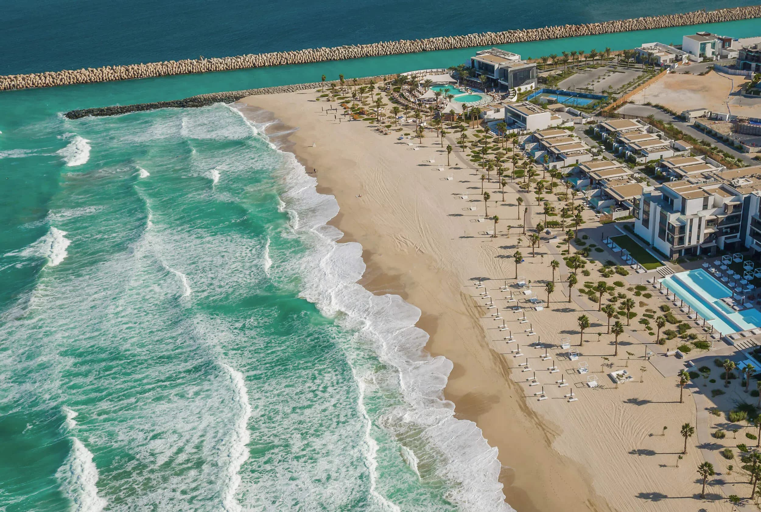 Aerial view of Nikki Beach Dubai resort, private shoreline, and pool on Pearl Jumeira