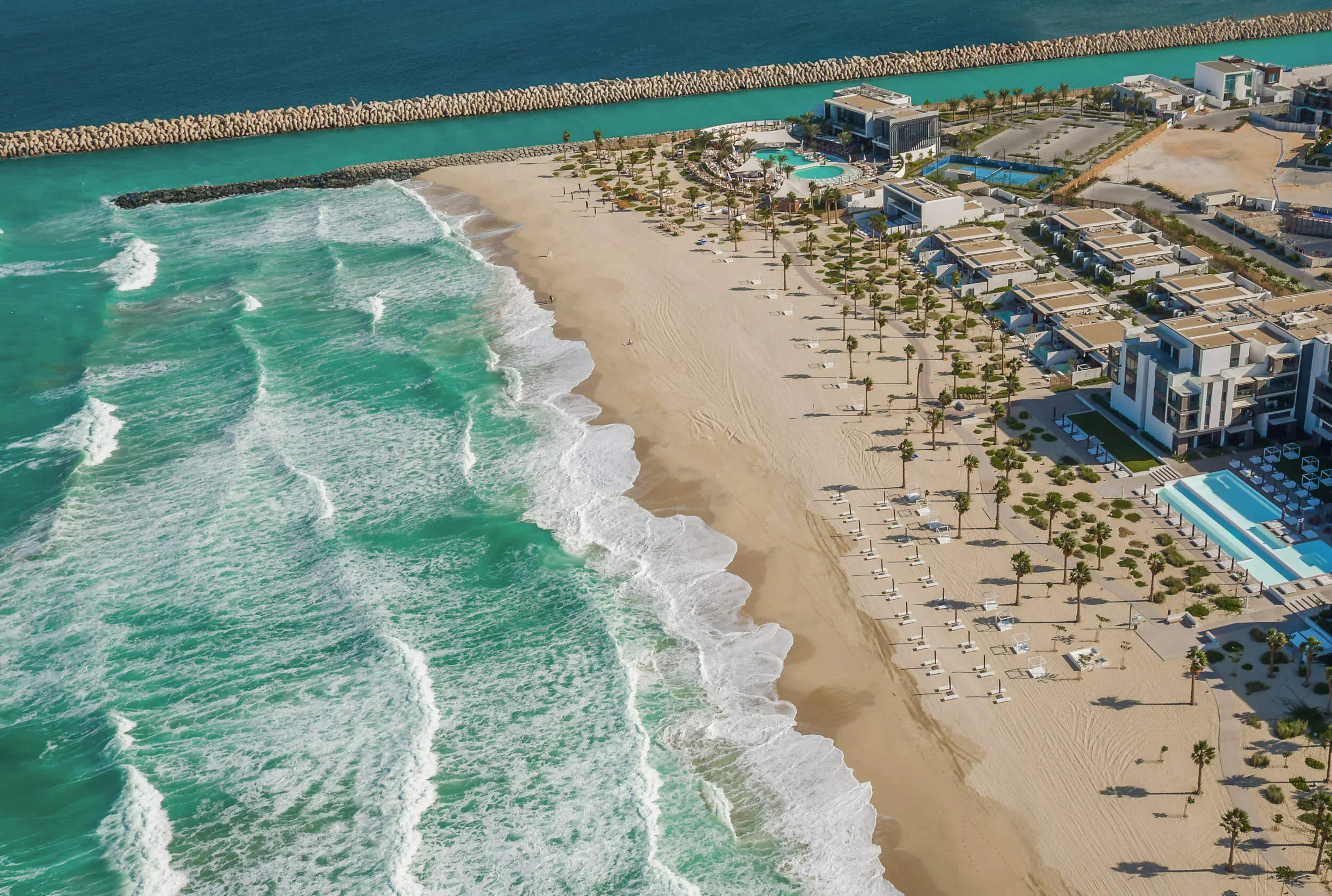Aerial view of Nikki Beach Dubai resort, private shoreline, and pool on Pearl Jumeira